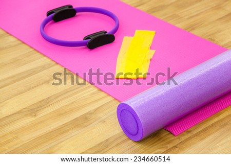 Roller, yoga mat, stability ring and yelow cloth on the parquet. Close-up shot.