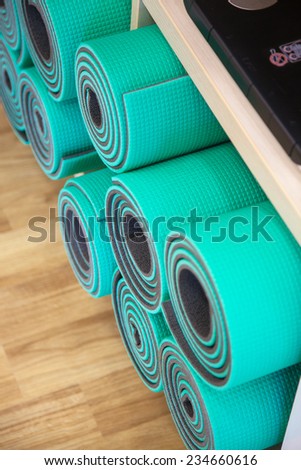 Exercise mats constricted, rolled-up on a shelf in the closet.