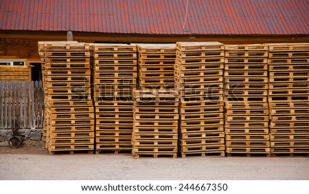 Wooden pallets near the warehouse, exactly stacked.