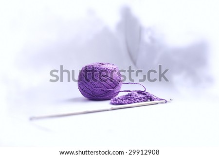 Knitting, ball, threads and crochet hook, on an abstract light background