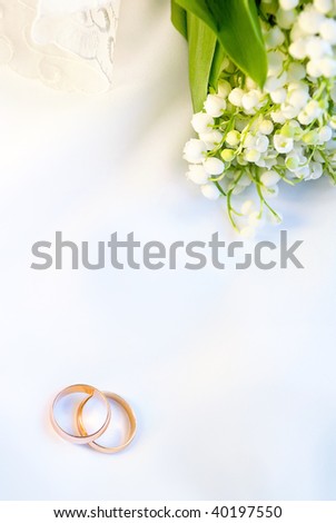 stock photo Wedding background with rings and lilies of the valley