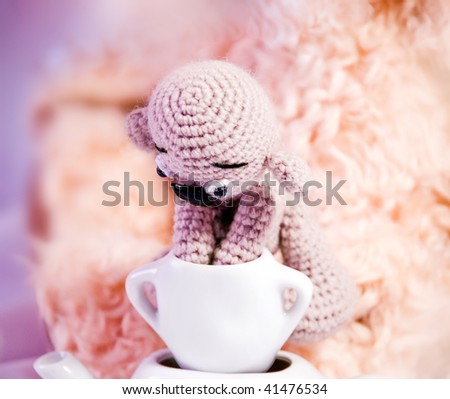 A little toy Teddy Bears put paws into a sugar-bowl standing on a tea-pot