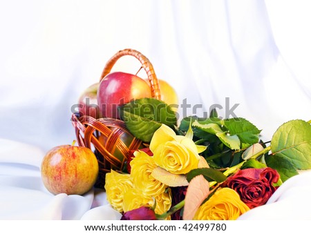 Still life with the basket of apples and roses. Sharpness on an overhead yellow rose.