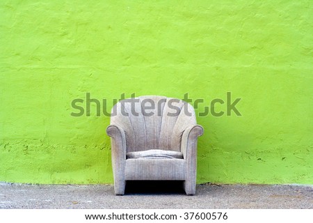 Single chair against green wall