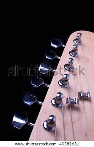 Guitar headstock, strings and tuners against a black background