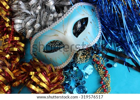 Blue carnival mask on a blue background with festive decorations