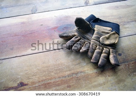 worn out working gloves on wood worktable