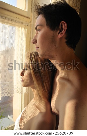 Young couple in love looking out of the window