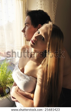beautiful couple in love looking out of the window