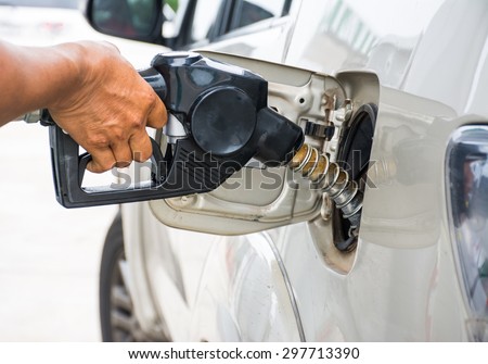 Closeup of man pumping gasoline fuel in car at gas station
