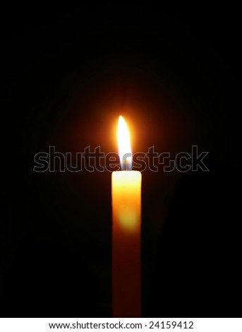 burning candle isolated on black background.