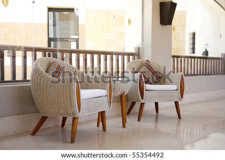 two armchairs end table in hall.