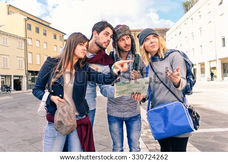 Group of tourists looking map - Couples of best friends in holiday lost in old town center - Young students seeking information on road map in city square - Concept of friendship tourism and education