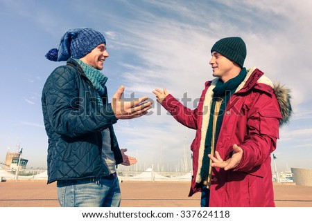 Men models wearing winter clothes using gesturing in friendly discussion - Best male friends are hugging - Trendy students having fun outdoor in sunny day - Concept of friendship happiness and youth