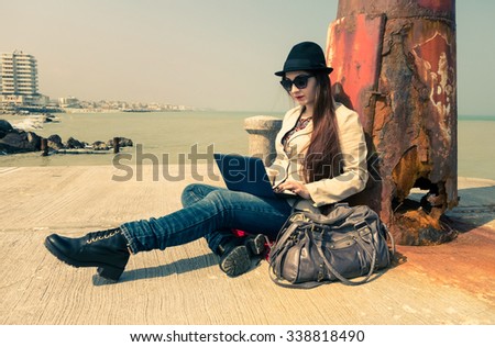 Young woman working with pc outdoor - Lonely girl writing using laptop wifi connected - Teenager model sitting next to old lighthouse on the dock of the bay - Misty vintage filtered look retro style