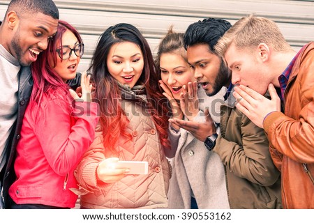 Multiracial group of young friends surprised face looking mobile phone new miracles technology - Mixed race best friendship and astonished facial expression concept - Main focus Indian man at right