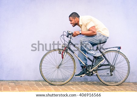 Black American African man in funny scene with locked old bike - Young afroamerican guy riding vintage bicycle with red padlock safe chained to wheel - Fun concept of cycle  theft and security tools