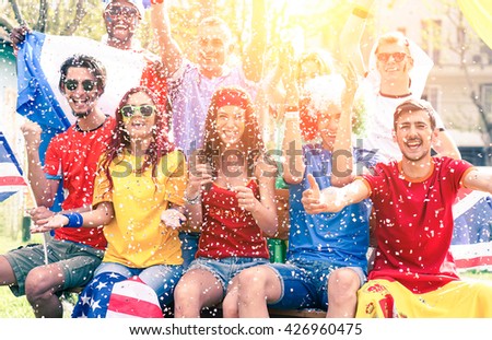Cheering football fans exulting watching match on screen outdoors - sport supporters party and fun for international soccer game - Multiracial concept of joy and togetherness  - Sun halo filter