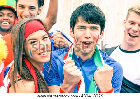 Sport supporter cheering at football stadium together with many multiracial fans - Young man at sportive event screaming at the moment of goal scored - Happiness and enthusiasm concept - Focus on male