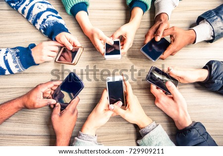 Hands circle using phones on table top view - Multiracial people holding mobile devices sitting around at office desk - Concept of friends team working and modern communication technology above image