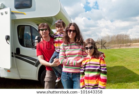 Family vacation in camping. Happy active parents with kids travel on camper (RV). Family having fun near their motorhome. Spring vacation trip with children.