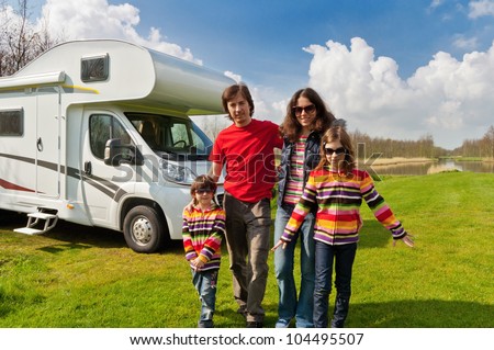 Family vacation in camping, camper trip. Happy active parents with kids travel on RV. Family having fun near their motorhome. Spring vacation trip with children.
