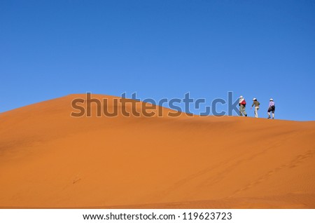 People walking on beautiful dune of Namib desert, traveling and hiking in South Africa