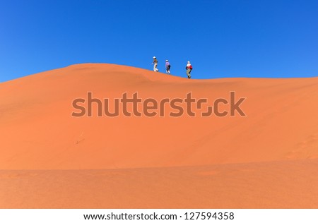 People walking on beautiful dune of Namib desert, traveling and hiking in South Africa