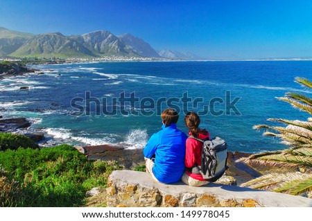 Happy couple looking at beautiful ocean view in Hermanus, romantic vacation in South Africa