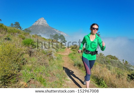 Active woman runner runs trail near Table mountain, Cape Town, South Africa. Running and fitness concept