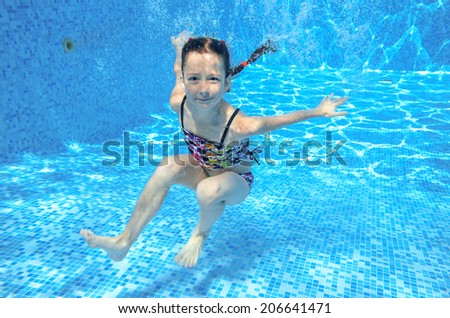 Happy active underwater child swims in pool, beautiful healthy girl swimming and having fun on family summer vacation, kids sport