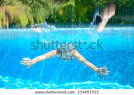 Child swims in swimming pool, playing and having fun, underwater and above view, kids sport and vacation