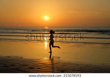 Silhouette of woman jogger running on sunset beach, fitness and healthy life concept