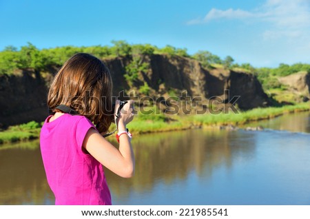 Girl taking river photo by camera, vacation in South Africa