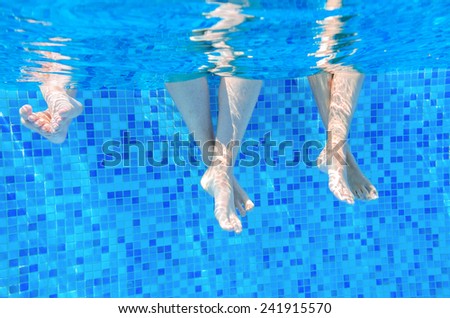 Funny underwater family legs in swimming pool, vacation and sport concept