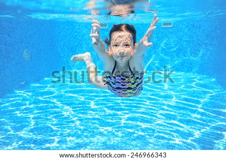 Kid swims in pool underwater, girl swimming, playing and having fun, children water sport
