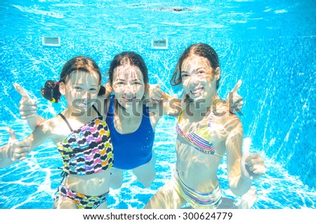 Family swim in pool underwater, happy active mother and children have fun in water, kids sport on family vacation