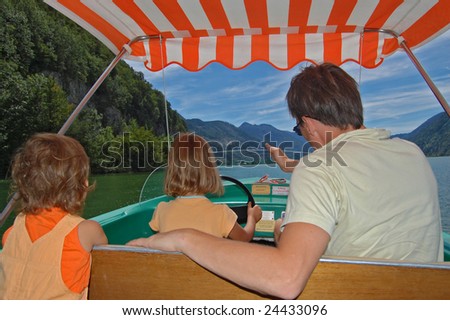 Family vacation. Father teaching his daughter to drive a boat