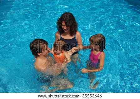 Happy smiling family with kids having fun in swimming pool