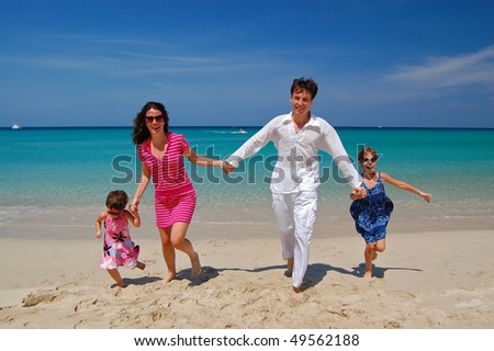 Happy family of four having fun on the beach. Family vacation