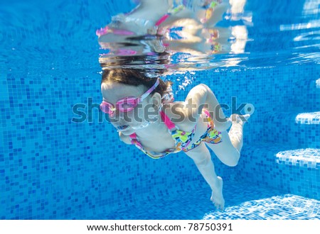 Underwater kid in swimming pool. Active girl swims. Child sport