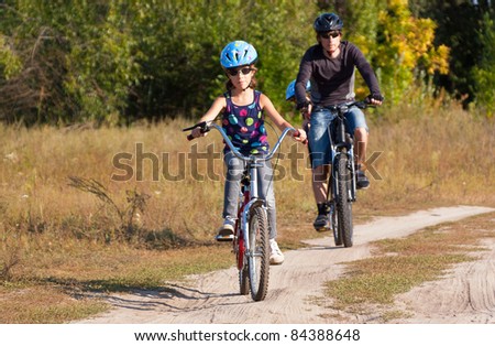 Family cycling. Father with children riding bicycle outdoors