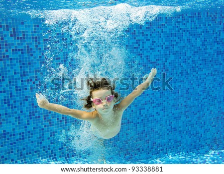 Happy active child jumps to swimming pool, underwater view. Kids sport on summer vacation