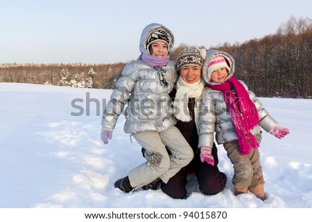 Winter family snow fun outdoors. Happy active mother with kids