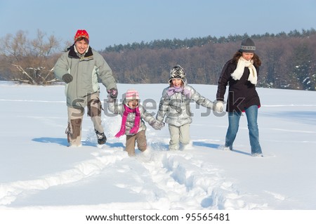 Happy family winter fun outdoors. Parents with kids playing with snow on winter vacation