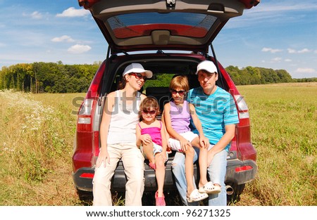 Family car trip on summer vacation. Happy active parents and two kids near car having fun outdoors
