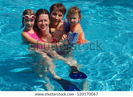 Family in swimming pool on vacation having fun, happy active parents with kids in water, sport and fitness concept