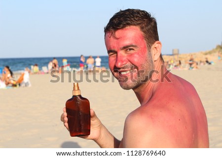 Man showing tanning lotion while getting sunburned