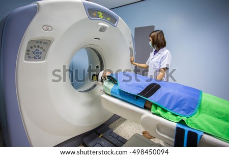 Radiologic technician mature female patient lying on a CT Scan bed