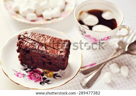 Chocolate cake and a cup of coffee. Table setting with china porcelain. Selective focus